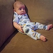 Dayton is registered to the contest to win money with this photo: baby, child, clothing, cookie_monster, couch, cute, expression, face, foot, furniture, hand, head, home, indoors, infant, pajamas, person, relaxing, seated, sofa