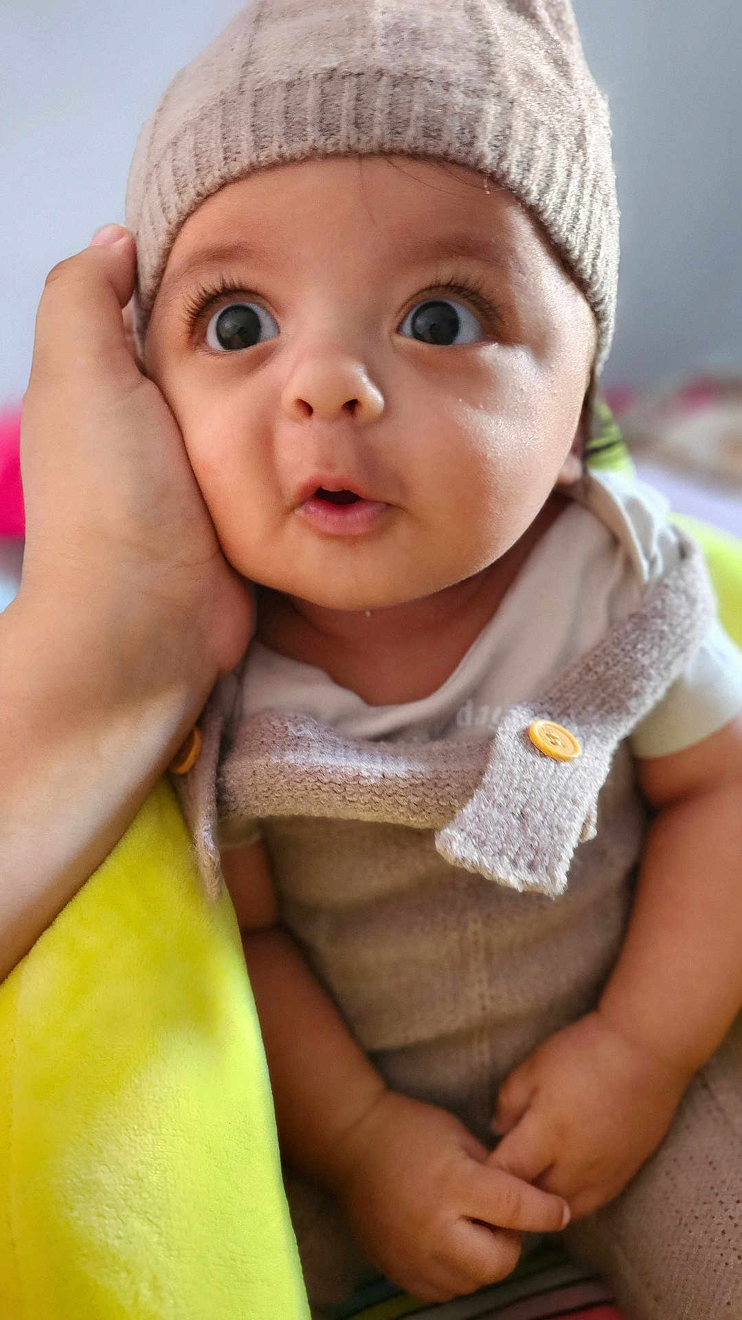 Amjed participe au concours pour gagner de l'argent avec cette photo : baby, button, child, clothing, cute, expression, eyes, face, hand, indoors, infant, knit_hat, mouth, person, portrait, sitting, skin, soft_texture, surprised, yellow_blanket