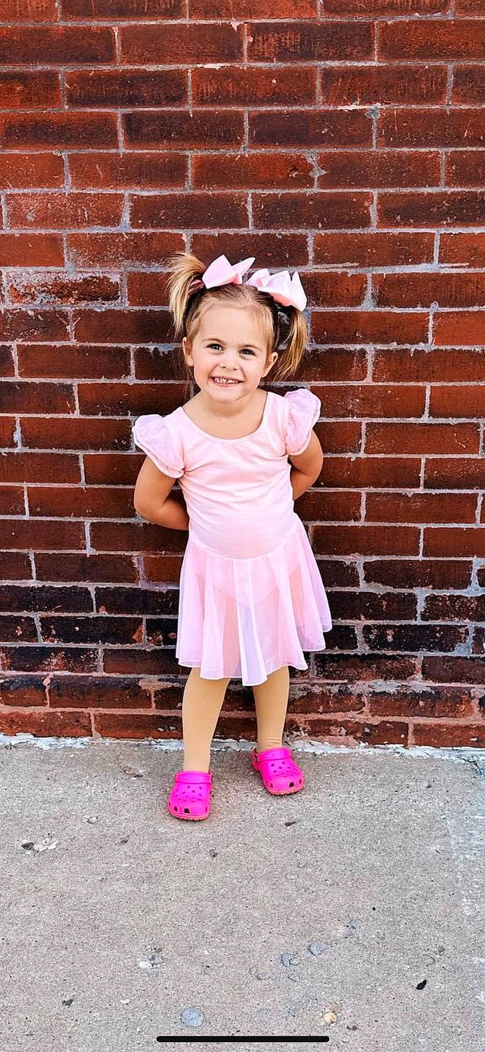 Bella joined the competition — help win amazing prizes! baby_toddler_clothing, brick, brickwork, child, clothing, day_dress, fashion_accessory, flash_photography, happy, human_leg, joy, magenta, pattern, person, pink, purple, sitting, sleeve, smile, sock