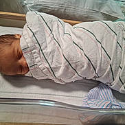 James joined the competition — help win amazing prizes! newborn, baby, swaddled, blanket, hospital, crib, sleeping, infant, bed, soft, striped, head, peaceful, resting, person, wrapped, cozy, toddler, indoor, cute