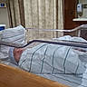 James joined the competition — help win amazing prizes! newborn, baby, hospital, bassinet, blanket, striped, sleeping, infant, wrapped, bed, curtains, pillow, wood, clear, medical, room, soft, peaceful, tender, patient