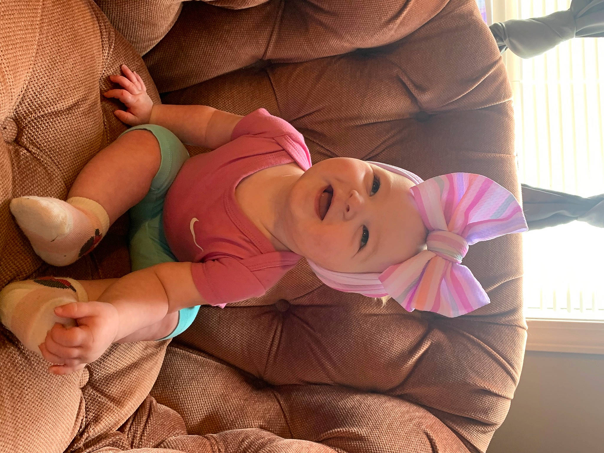 Delilah is registered to the contest to win money with this photo: abdomen, chest, child, comfort, elbow, gesture, happy, hat, headwear, human_leg, knee, lap, linens, nail, person, pink, skin, smile, textile, thigh