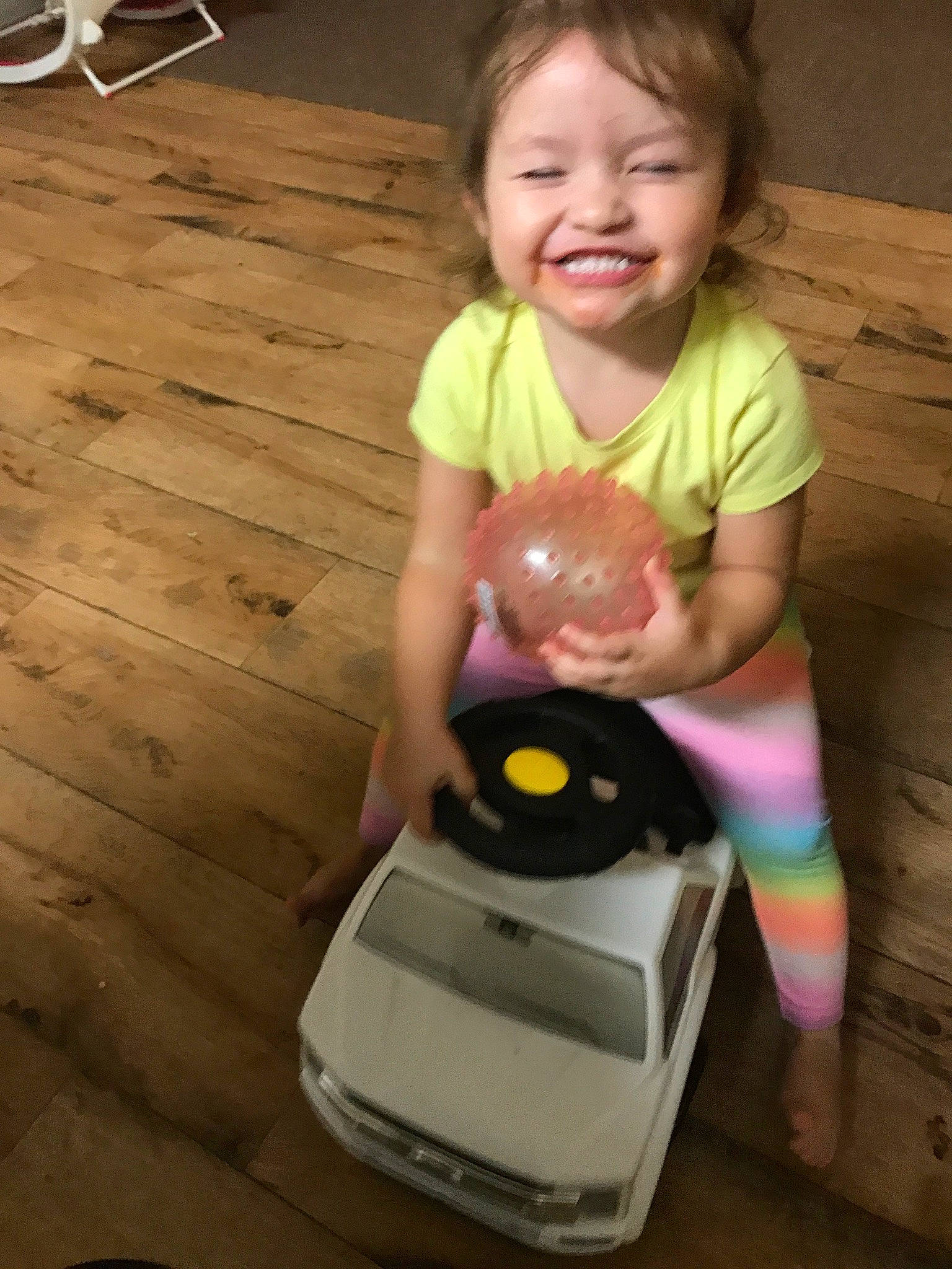 Aurora is registered to the contest to win money with this photo: baby, baby_toddler_clothing, child, floor, flooring, hardwood, home_appliance, homemaker, joy, laminate_flooring, laugh, outdoor_furniture, outdoor_table, person, pink, plank, plastic, toddler, wood, wood_flooring