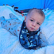 Brecklan is registered to the contest to win money with this photo: baby, bib, blanket, blue, camouflage, child, cowboy, cute, expression, fabric, face, fluffy, indoor, infant, looking_at_camera, lying_down, onesie, portrait, soft, tent