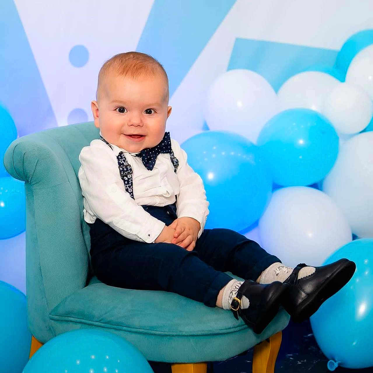 Darius a rejoint le concours — aidez-le/la à gagner de superbes lots ! baby, balloons, blue, bow_tie, boy, celebration, chair, child, clothing, cute, face, floor, happy, indoors, portrait, shoes, smile, socks, suspenders, white