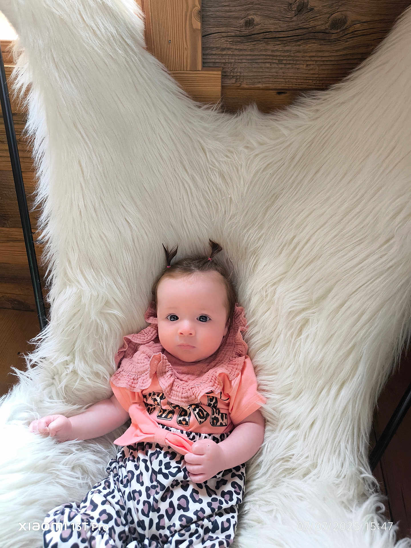 Adriana a rejoint le concours — aidez-le/la à gagner de superbes lots ! baby, infant, child, cute, pigtails, fluffy_chair, leopard_print, pink_top, wooden_wall, indoor, portrait, sitting, clothing, person, young_child, cozy, soft_texture, relaxed, bright_eyes, casual