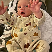 Achille participe au concours pour gagner de l'argent avec cette photo : baby, infant, onesie, mountain_pattern, clothing, person, hand, face, expression, indoor, floor, tile, lap, sitting, young_child, cute, wide_eyes, open_mouth, reaching, cozy