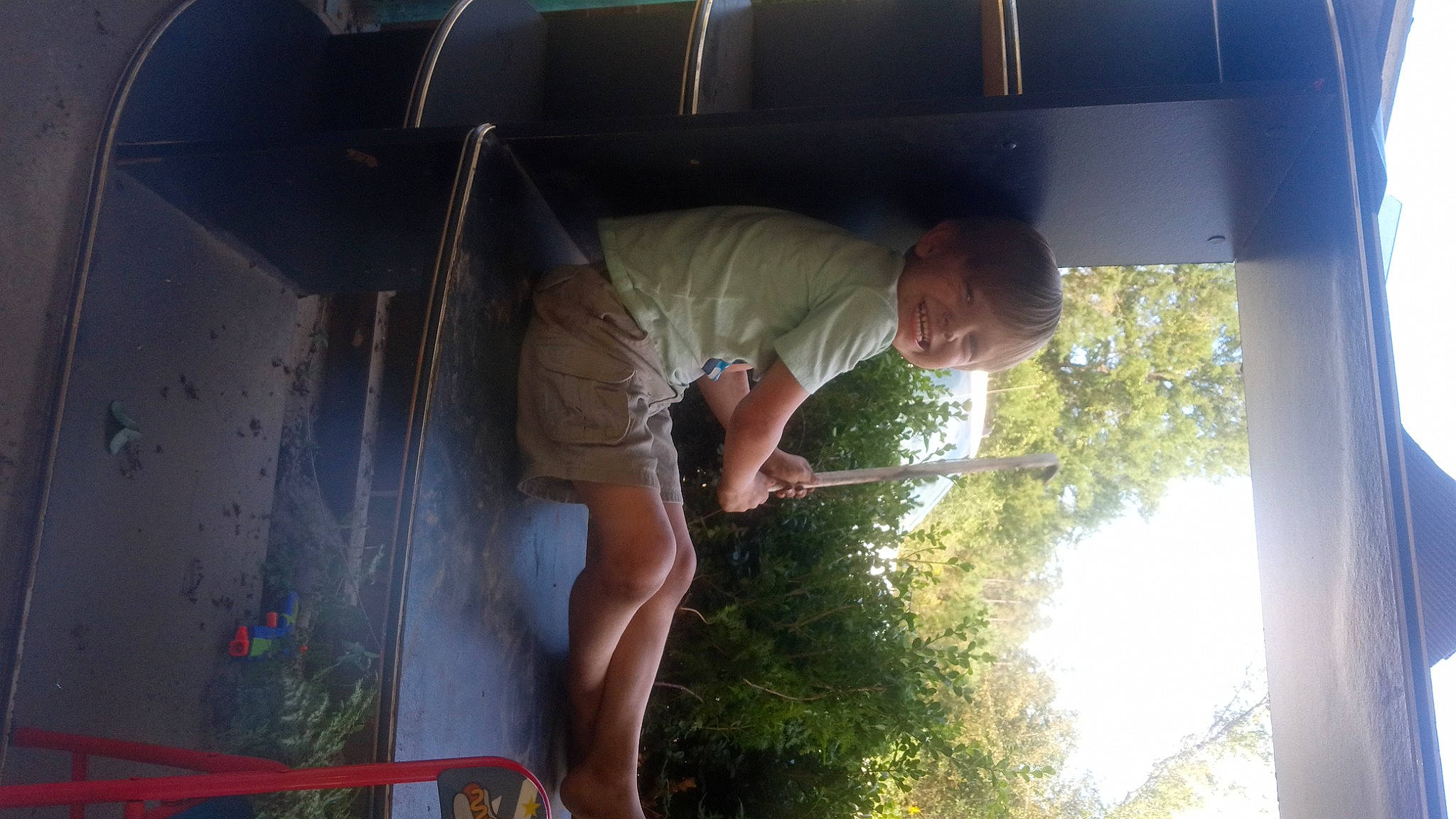 Alexander is registered to the contest to win money with this photo: automotive_exterior, automotive_window_part, child, elbow, fun, glass, grass, human_leg, joy, leisure, person, plant, shorts, t_shirt, tints_and_shades, tree, vehicle_door, window