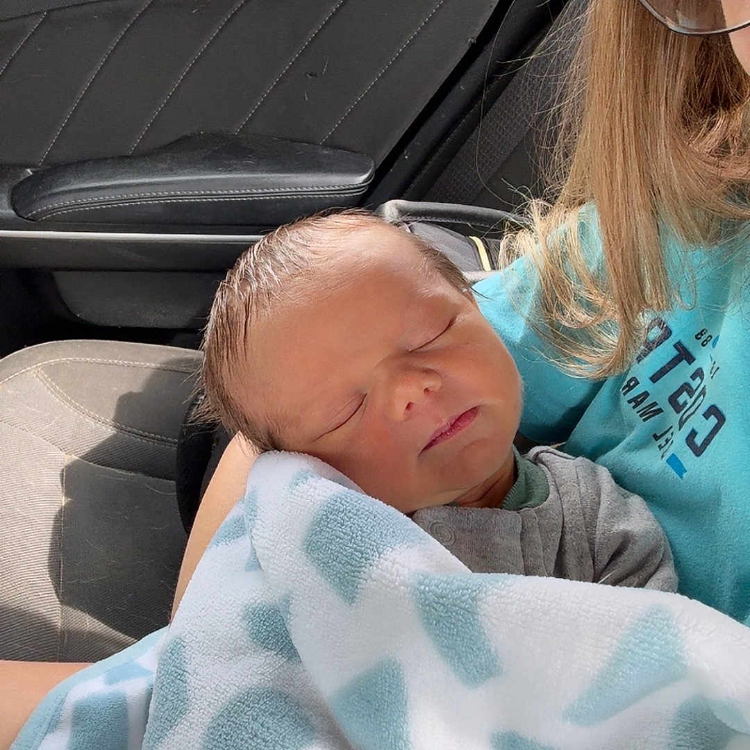 Xavier is registered to the contest to win money with this photo: accessories, adult, baby, blanket, car, cushion, face, female, glasses, head, homedecor, machine, newborn, person, photography, portrait, transportation, vehicle, wheel, woman