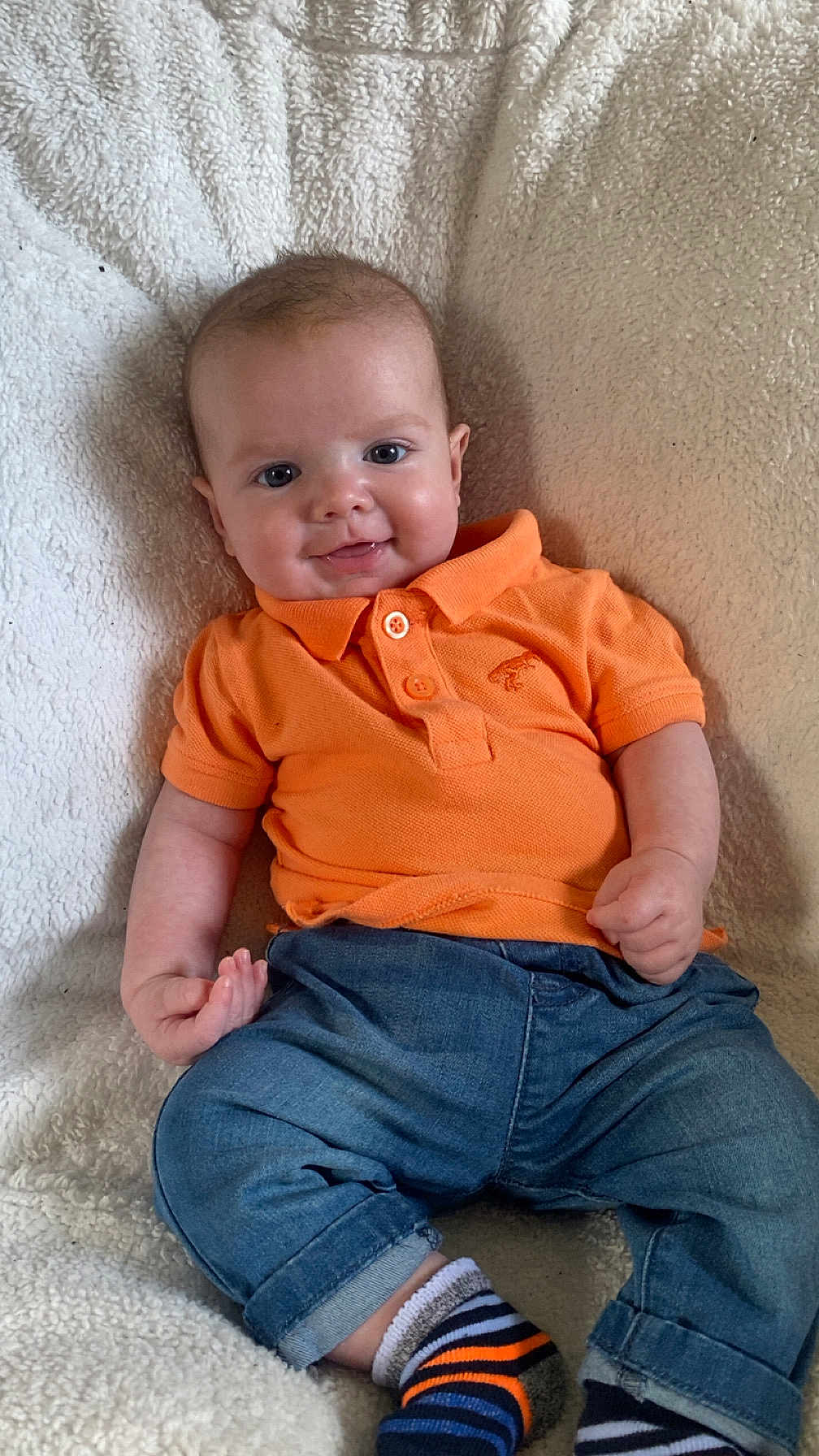 Vinny-Dean joined the competition — help win amazing prizes! baby, blanket, casual, child, clothing, cozy, cute, denim_pants, face, feet, happy, indoor, infant, orange_shirt, person, portrait, sitting, smile, striped_socks, young_child