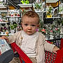 Malone participe au concours pour gagner de l'argent avec cette photo : toddler, child, shopping_cart, store, flowers, plants, cardigan, beige, red, curly_hair, indoor, retail, portrait, cute, baby, casual_clothing, young_child, expression, shopping, colorful