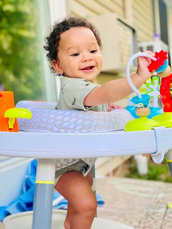 Cory is registered to the contest to win money with this photo: baby_playing_with_toys, baby_toddler_clothing, chair, child, facial_expression, fun, hairstyle, happy, leisure, outdoor_furniture, person, photograph, product, recreation, shorts, skin, smile, summer, thigh, toddler