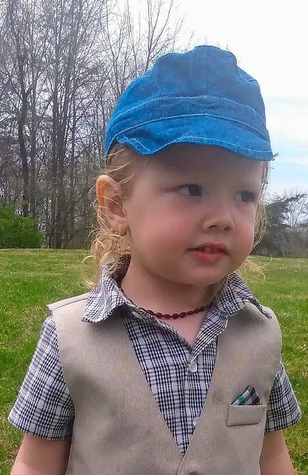 Korbin is registered to the contest to win money with this photo: beauty, cap, child, chin, collar, dress_shirt, electric_blue, grass, headgear, headwear, lip, neck, pattern, person, photograph, plaid, plant, sky, sleeve, toddler
