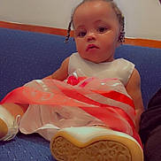 Damiyah joined the competition — help win amazing prizes! child, toddler, dress, shoe, sole, couch, blue_couch, sitting, indoor, portrait, cute, braided_hair, white_shoe, patterned_sole, baby, fashion, relaxed, person, furniture, young_child