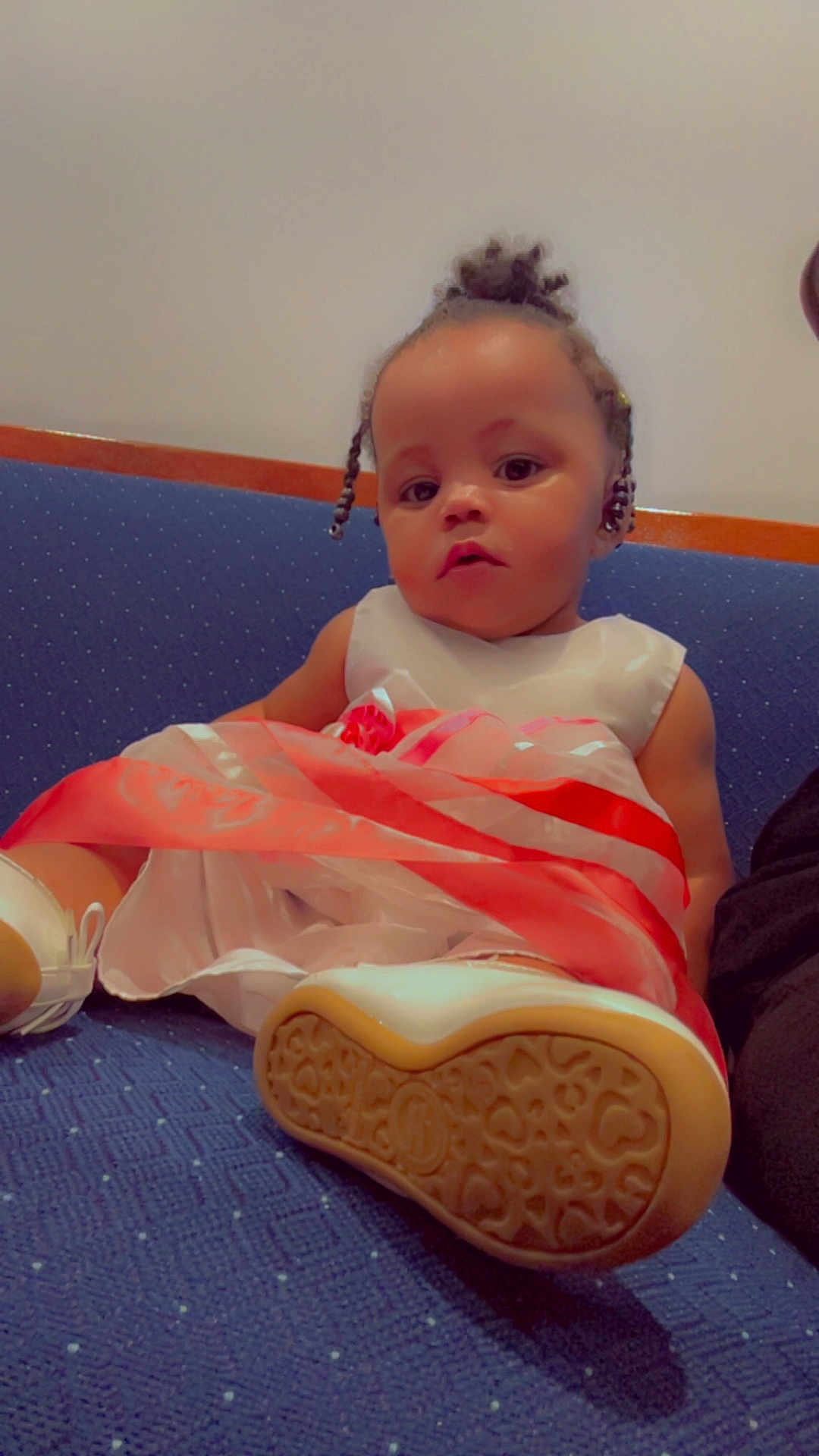Damiyah joined the competition — help win amazing prizes! child, toddler, dress, shoe, sole, couch, blue_couch, sitting, indoor, portrait, cute, braided_hair, white_shoe, patterned_sole, baby, fashion, relaxed, person, furniture, young_child