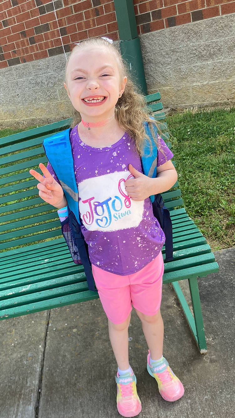 Kyleigh is registered to the contest to win money with this photo: active_pants, electric_blue, grass, green, happy, human_leg, joy, knee, leg, leisure, magenta, pattern, person, pink, recreation, shoulder, sleeve, smile, sportswear, t_shirt