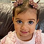 Samara is registered to the contest to win money with this photo: toddler, child, smiling, pink_clothing, hair_clips, flower_clips, big_eyes, frills, cute, indoors, couch, leather_couch, face, portrait, baby, person, happy, seated, red_crab, kitchen_background