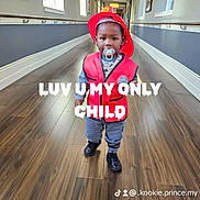 Prince is registered to the contest to win money with this photo: toddler, child, firefighter_costume, red_helmet, red_vest, pacifier, hallway, wooden_floor, windows, indoor, person, cute, standing, baby, floor, clothing, smile, young_child, portrait, costume