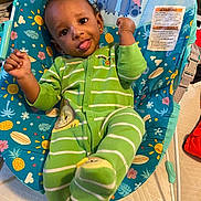 Cameron joined the competition — help win amazing prizes! baby, child, onesie, green_clothing, striped_clothing, baby_chair, colorful, sun_pattern, pineapple_pattern, flower_pattern, indoor, playful, tongue_out, cheeky, raising_fist, smiling, person, infant, cute, furniture