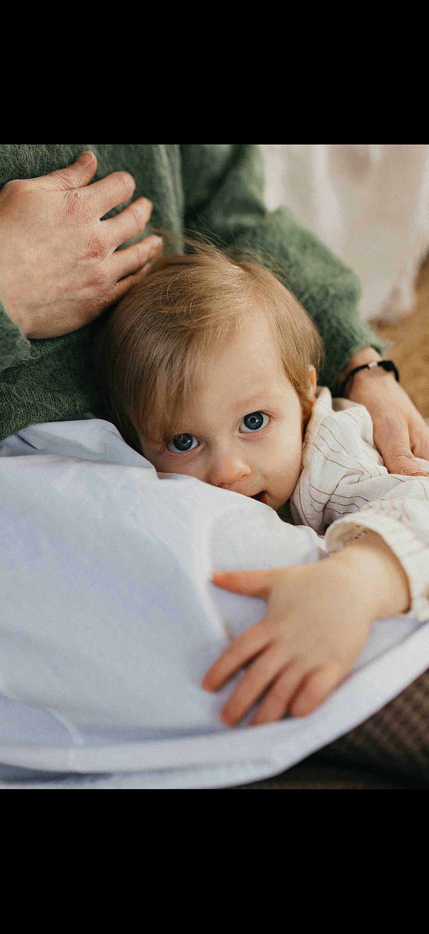 Basile participe au concours pour gagner de l'argent avec cette photo : child, baby, toddler, blue_eyes, close_up, portrait, cuddling, blanket, adult_hand, sweater, indoor, cozy, looking_at_camera, bedtime, small_hand, cute, snuggle, fabric, mouth, soft_lighting