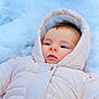 baby, child, snow, winter_clothing, snowsuit, hood, cold, outdoor, face, blue_eyes, pale_pink, winter, infant, skin, cheeks, expression, lying_down, soft, warm, nature