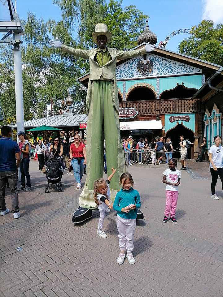 Liana a rejoint le concours — aidez-le/la à gagner de superbes lots ! city, crowd, entertainment, event, footwear, fun, human_settlement, infrastructure, leisure, pedestrian, person, plant, pole, public_event, sculpture, sky, statue, street, tourism, travel