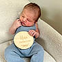 baby, newborn, infant, blue_outfit, plaque, wooden_sign, one_week, sitting, chair, soft_texture, cozy, portrait, cute, indoors, child, face, hands, feet, skin, expression