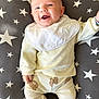 Simon participe au concours pour gagner de l'argent avec cette photo : baby, smiling, infant, pajamas, bib, face, person, lying_down, cushion, star_pattern, clothing, cute, happy, child, indoor, soft_texture, comfortable, adorable, portrait, young