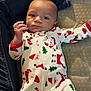baby, infant, child, face, onesie, pajamas, christmas_pattern, santa_print, lying_down, mattress, denim, jeans, leg, hand, eyes, cozy, indoor, portrait, cute, fabric