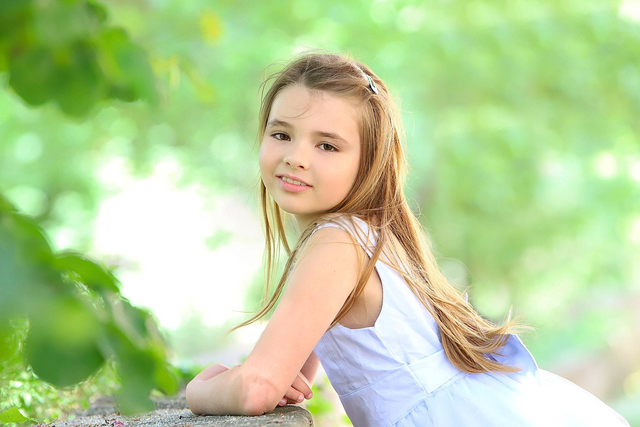 Emilia participe au concours pour gagner de l'argent avec cette photo : blond, brown_hair, dress, flash_photography, forest, fun, grass, hairstyle, happy, joy, leisure, long_hair, natural_landscape, people_in_nature, person, plant, portrait_photography, sitting, smile, toddler