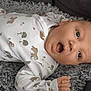 Ezio a rejoint le concours — aidez-le/la à gagner de superbes lots ! baby, infant, onesie, animal_print, carpet, gray, expression, surprised, mouth_open, lying_down, cute, child, skin, hand, face, indoors, soft_texture, clothing, head, portrait