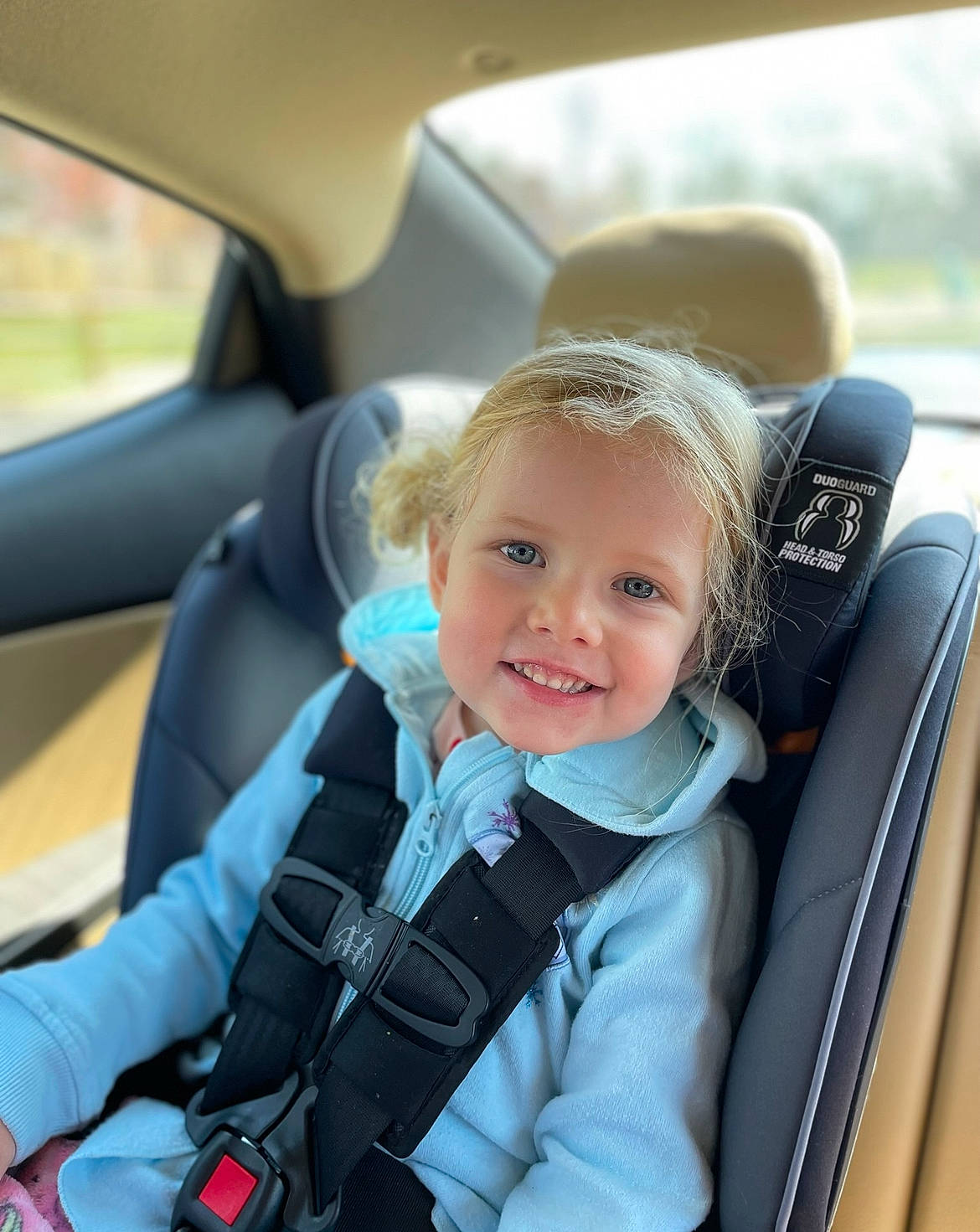 Samantha is registered to the contest to win money with this photo: auto_part, automotive_design, automotive_exterior, car, car_seat, car_seat_cover, child, comfort, electric_blue, head_restraint, joy, motor_vehicle, person, personal_luxury_car, plant, product, smile, steering_part, steering_wheel, toddler