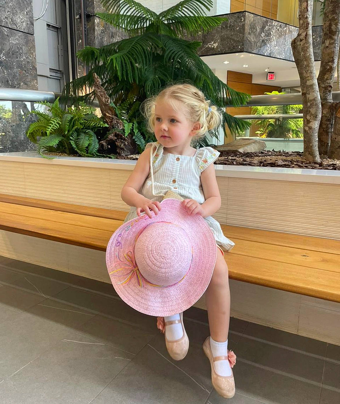 Samantha joined the competition — help win amazing prizes! baby_toddler_clothing, child, flooring, fun, happy, human_leg, knee, leg, leisure, palm_tree, person, pink, plant, sandal, sitting, sock, thigh, toddler, tree, window