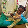 Nichol Mae Harris is registered to the contest to win money with this photo: toddler, child, indoor, pajamas, inflatable_ring, cushion, floor, pigtails, curious, baby, toy, colorful, animal_prints, foot, tile_floor, looking_up, person, infant, cute, home