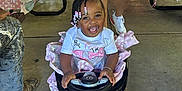 Nichol Mae Harris joined the competition — help win amazing prizes! toddler, toy_car, smile, child, party, balloon, beads, braids, person, shorts, sneakers, table, picnic, outdoor, celebration, pink, happy, steering_wheel, event, family