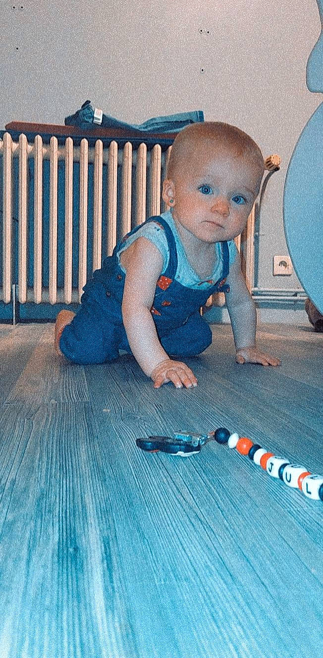 Julia a rejoint le concours — aidez-le/la à gagner de superbes lots ! baby, baby_toddler_clothing, blue, child, electric_blue, finger, floor, flooring, foot, fun, hardwood, human_leg, knee, pattern, person, sitting, t_shirt, textile, toddler, toy