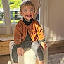 barefoot, cardigan, carpet, child, cozy, curtains, furniture, happy, home, indoor, natural_light, ottoman, pants, person, portrait, smiling, sunlight, toddler, window, wooden_floor