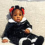 toddler, child, sitting, couch, black_jacket, white_fur, polka_dot_leggings, red_bows, beads, hair, face, expression, indoor, furniture, cute, portrait, person, clothing, footwear, cozy