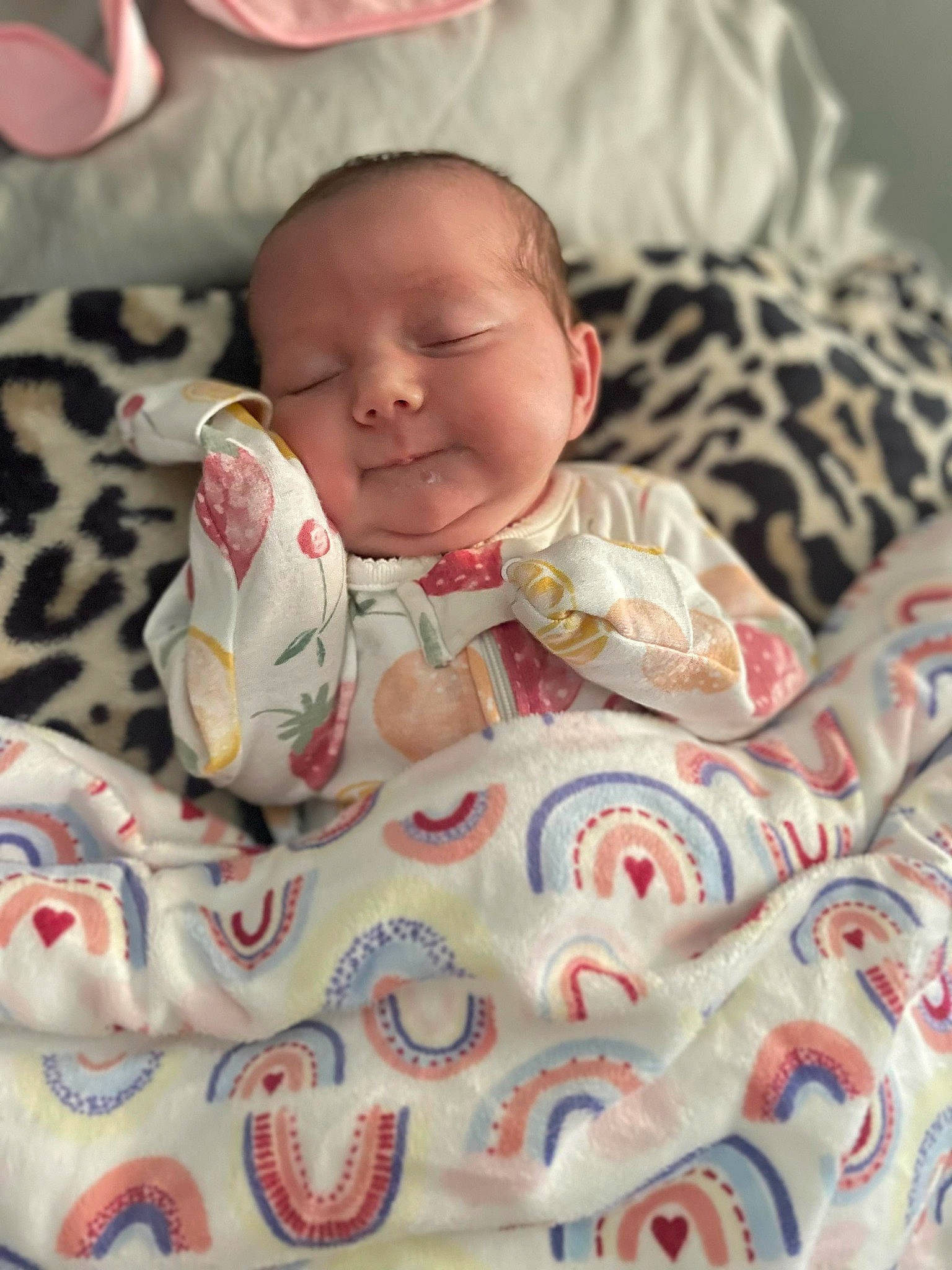 Ella is registered to the contest to win money with this photo: baby, baby_products, baby_toddler_clothing, cheek, child, comfort, face, happy, head, human_body, linens, nose, pattern, person, pink, skin, sleeve, smile, textile, toddler