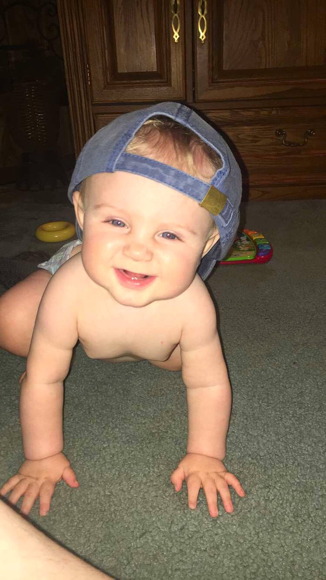 Dexter is registered to the contest to win money with this photo: arm, boy, cheek, child, ear, face, finger, fun, hair_accessory, hand, head, headgear, headwear, infant, joy, leg, mouth, person, sitting, skin