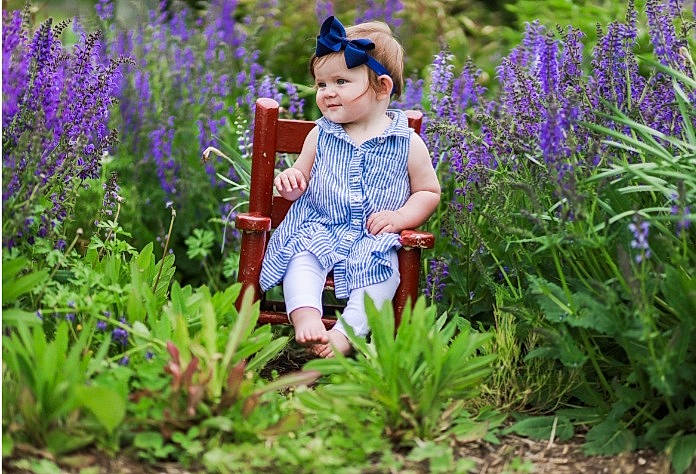 Sutton is registered to the contest to win money with this photo: botany, electric_blue, flower, flowering_plant, grass, grassland, green, groundcover, happy, hat, headwear, iris, landscape, leaf, people_in_nature, person, plant, purple, shrub, terrestrial_plant