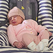 émilia participe au concours pour gagner de l'argent avec cette photo : baby, sleeping, pink_clothing, knit_hat, knit_sweater, baby_rocker, striped, stars, hearts, infant, cozy, cute, indoor, resting, small_hands, socks, floor, relaxed, child, newborn