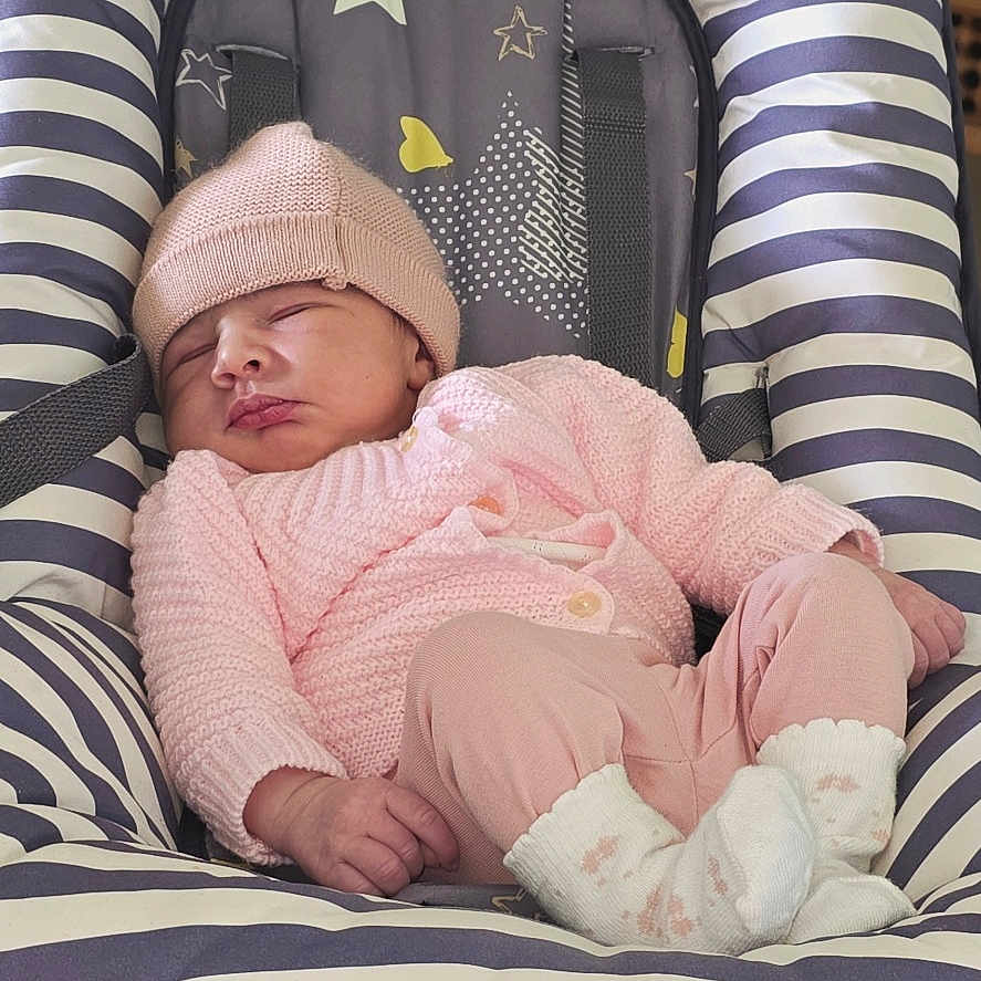 émilia participe au concours pour gagner de l'argent avec cette photo : baby, sleeping, pink_clothing, knit_hat, knit_sweater, baby_rocker, striped, stars, hearts, infant, cozy, cute, indoor, resting, small_hands, socks, floor, relaxed, child, newborn