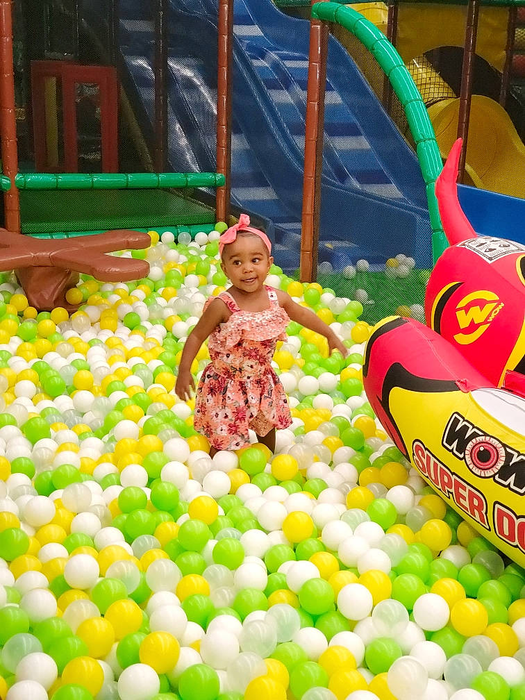 Aris is registered to the contest to win money with this photo: ball, ball_pit, balloon, child, event, fun, grass, green, headwear, joy, leisure, nonbuilding_structure, party, party_supply, person, photograph, play, playground, public_space, recreation