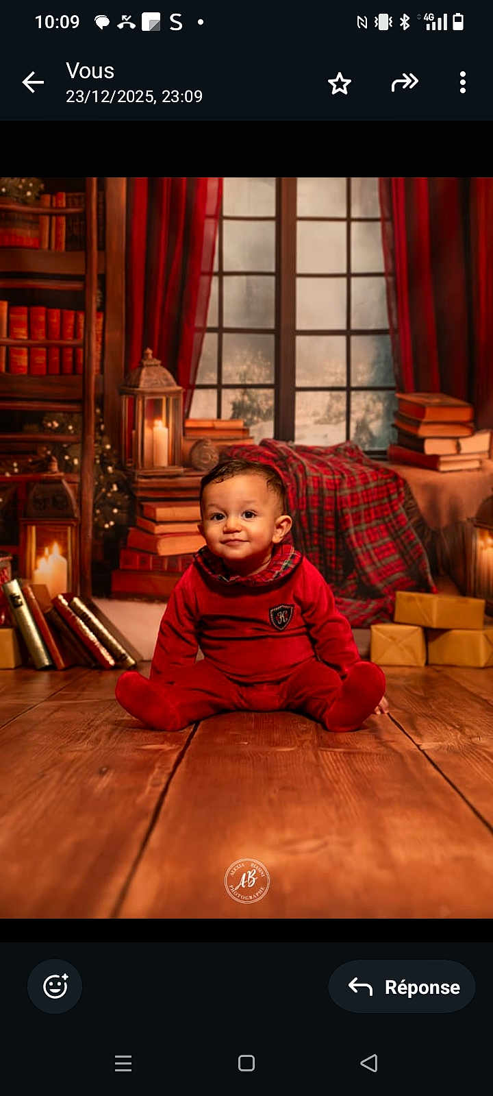 Zyan a rejoint le concours — aidez-le/la à gagner de superbes lots ! baby, child, red_clothing, pajamas, wooden_floor, books, candles, wrapped_presents, plaid_blanket, window, curtains, indoors, holiday_theme, smiling, sitting, portrait, cozy, warm_lighting, decor, festive