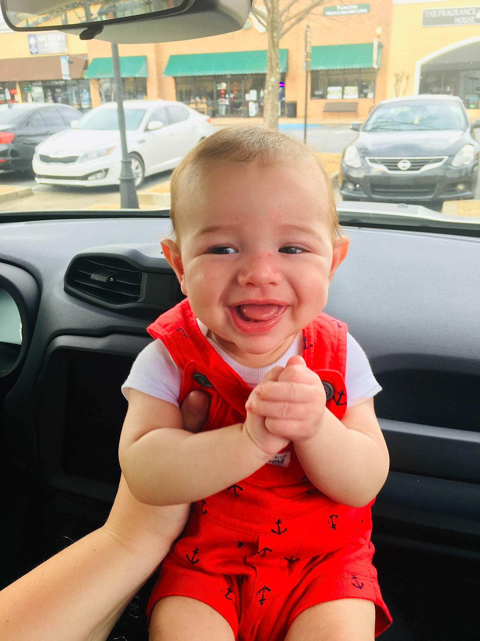 Sullivan is registered to the contest to win money with this photo: arm, baby, car, cheek, child, cool, face, facial_expression, finger, hand, head, joy, person, product, red, skin, smile, summer, toddler, vacation