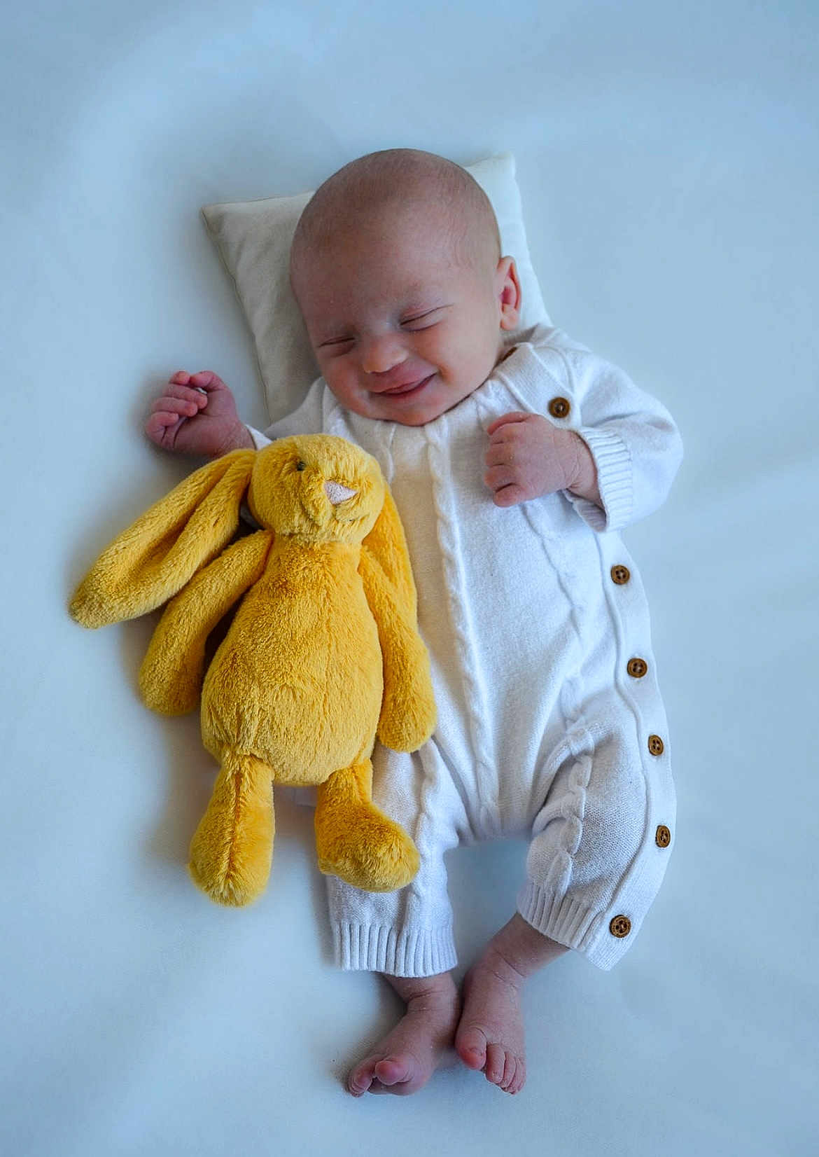 Arthur joined the competition — help win amazing prizes! baby, infant, smiling, sleeping, plush_toy, yellow_bunny, white_onesie, soft_surface, cute, peaceful, newborn, child, cozy, relaxed, baby_feet, toy, cuddly, portrait, sleepwear, small_hands