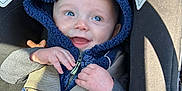 Caspian joined the competition — help win amazing prizes! baby, child, car_seat, blue_hoodie, smiling, happy, safety_harness, infant, cute, face, portrait, clothing, seatbelt, young_child, hands, headwear, indoors, closeup, person, baby_boy