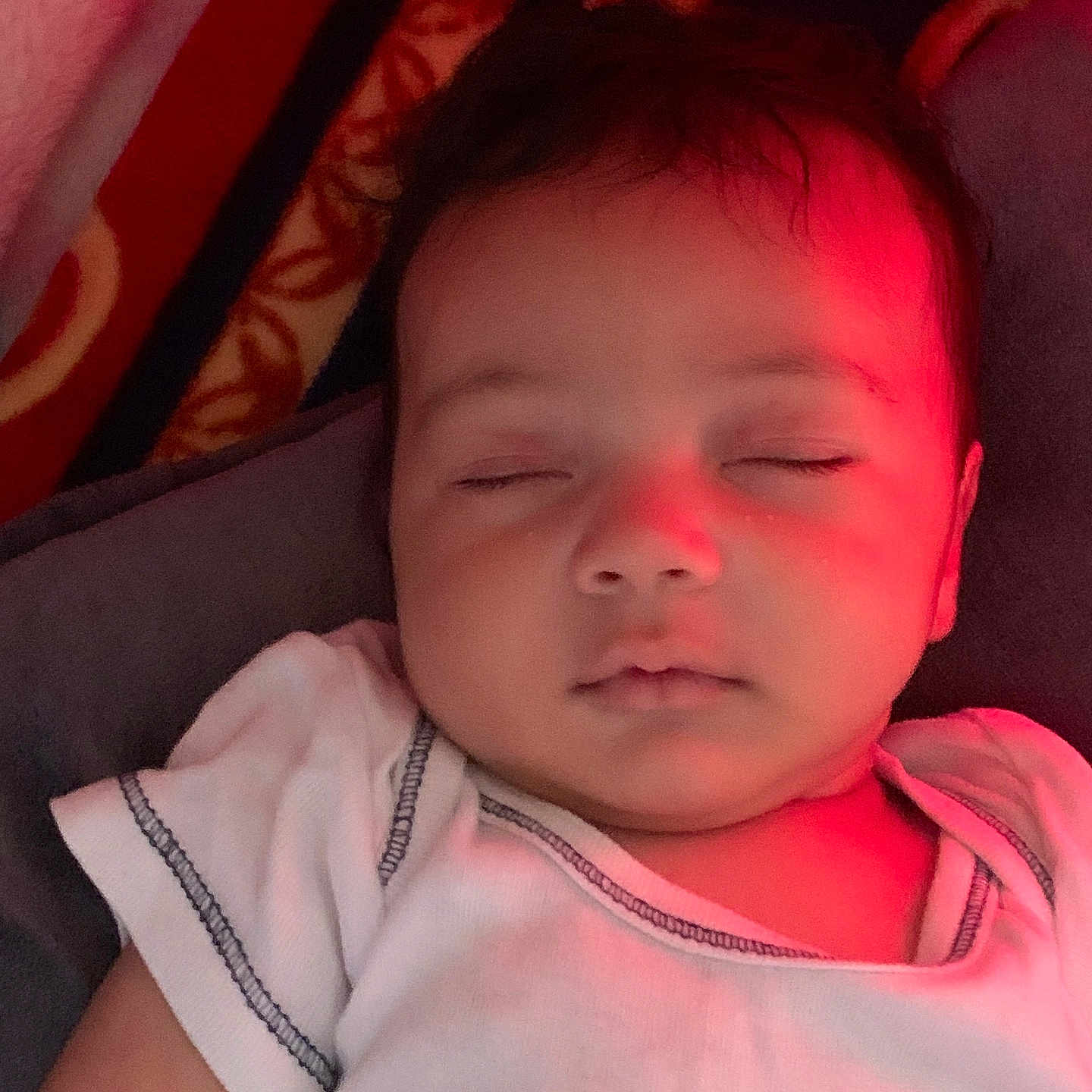 Riyad a rejoint le concours — aidez-le/la à gagner de superbes lots ! baby, child, closeup, comfort, cozy, cuteness, face, indoors, infant, patterned_blanket, peaceful, portrait, red_light, relaxation, rest, skin, sleeping, soft_light, white_onesie, young_child