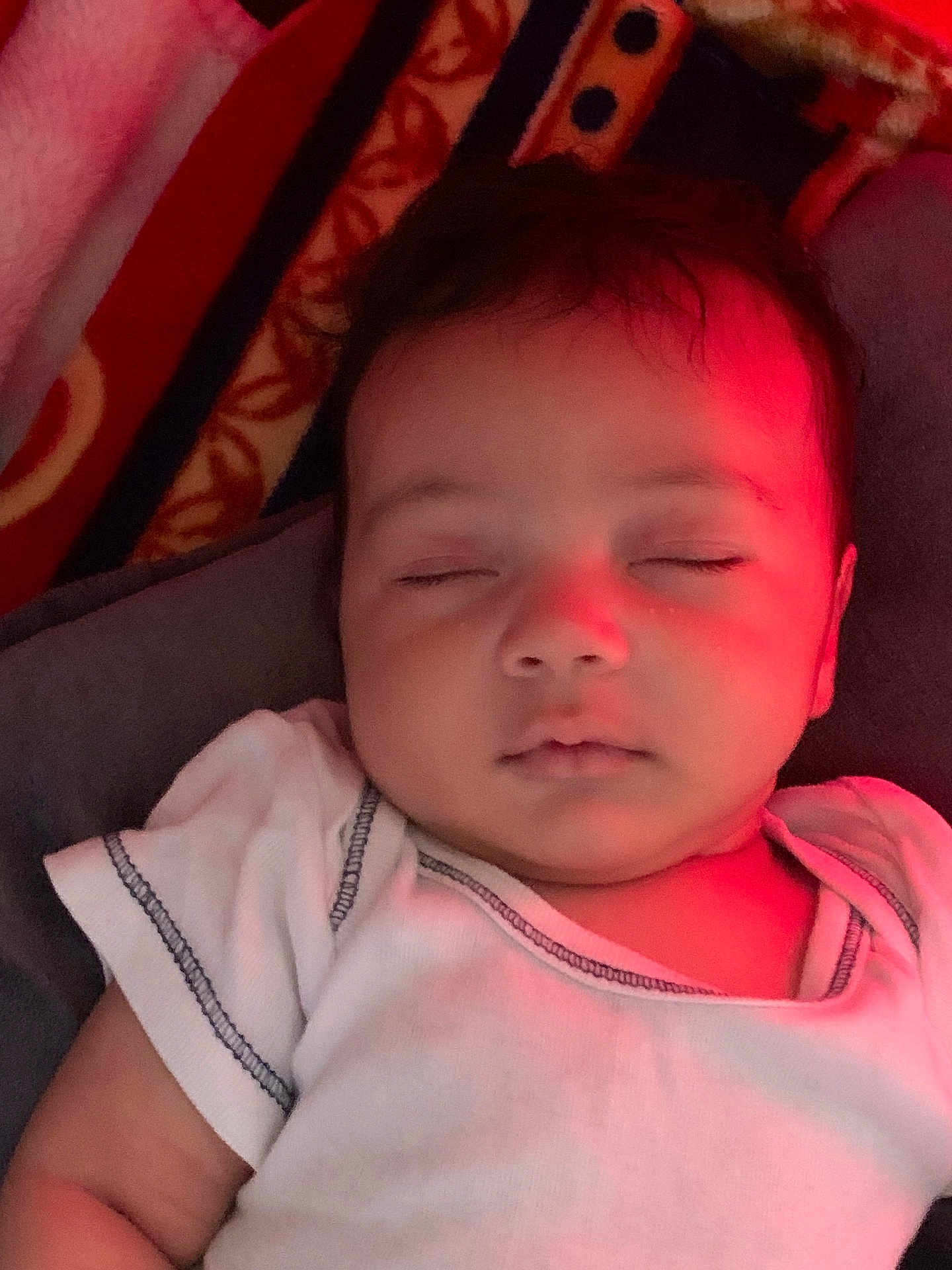 Riyad a rejoint le concours — aidez-le/la à gagner de superbes lots ! baby, sleeping, infant, white_onesie, red_light, peaceful, face, child, closeup, portrait, indoors, soft_light, cuteness, young_child, relaxation, rest, skin, patterned_blanket, comfort, cozy